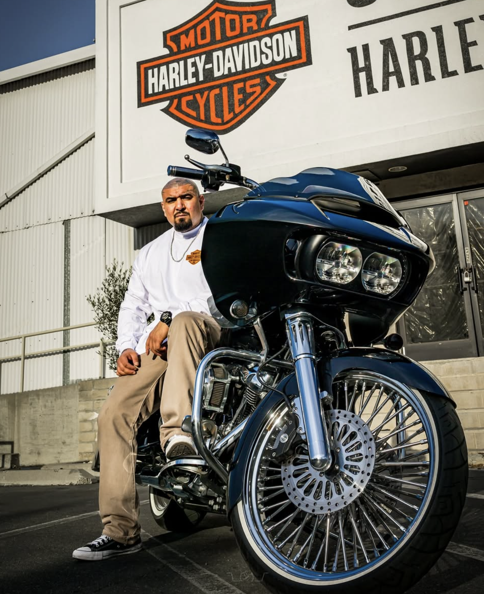 Lucky seated on a custom Road Glide outside the Harley Davidson dealership that houses one of his barber studios.